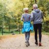 Cheerful active senior couple jogging in the park. Exercise toge