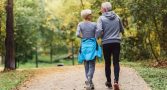 Cheerful active senior couple jogging in the park. Exercise toge